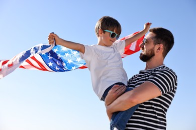 Photo of Happy father and son with flag of USA outdoors