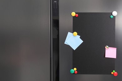 Photo of Black magnetic board and notes on refrigerator