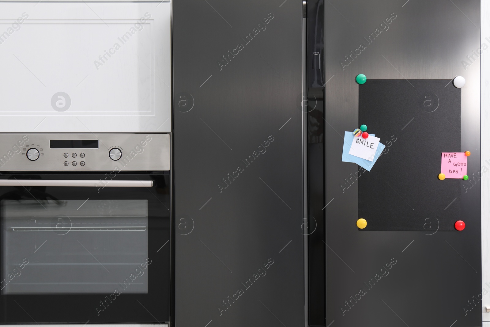 Photo of Magnetic board and notes on refrigerator in kitchen