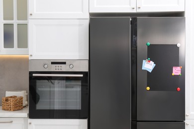 Photo of Magnetic board and notes on refrigerator in kitchen