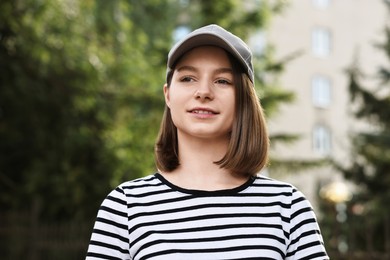 Portrait of smiling woman in baseball cap outdoors