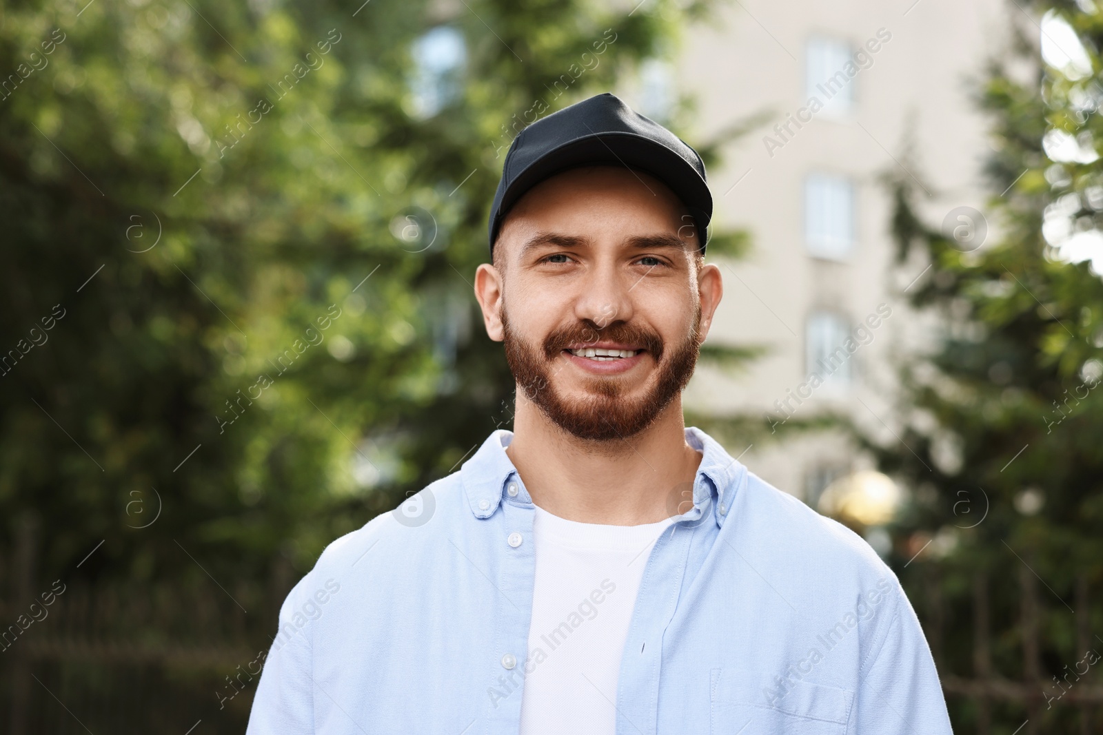 Photo of Portrait of smiling man in baseball cap outdoors