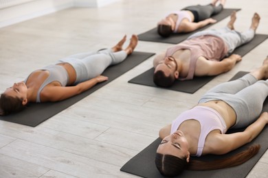 Group of people meditating on mats in yoga class