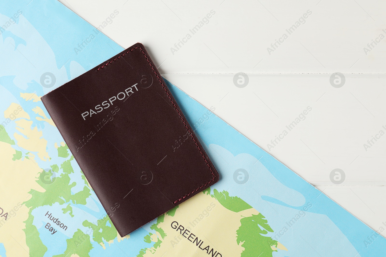 Photo of Passport and world map on white wooden table, flat lay