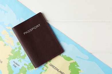 Passport and world map on white wooden table, flat lay