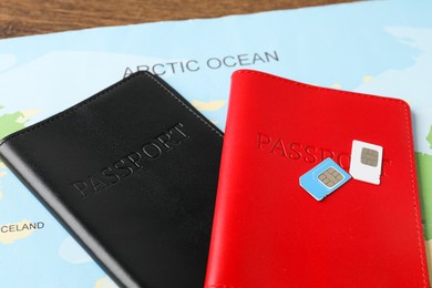 Passports, SIM cards and world map on table