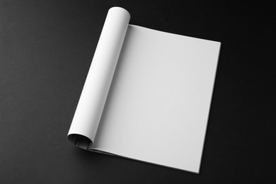 Photo of Open magazine with blank page on black background. Mockup for design