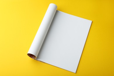 Photo of Open magazine with blank page on yellow background, above view. Mockup for design