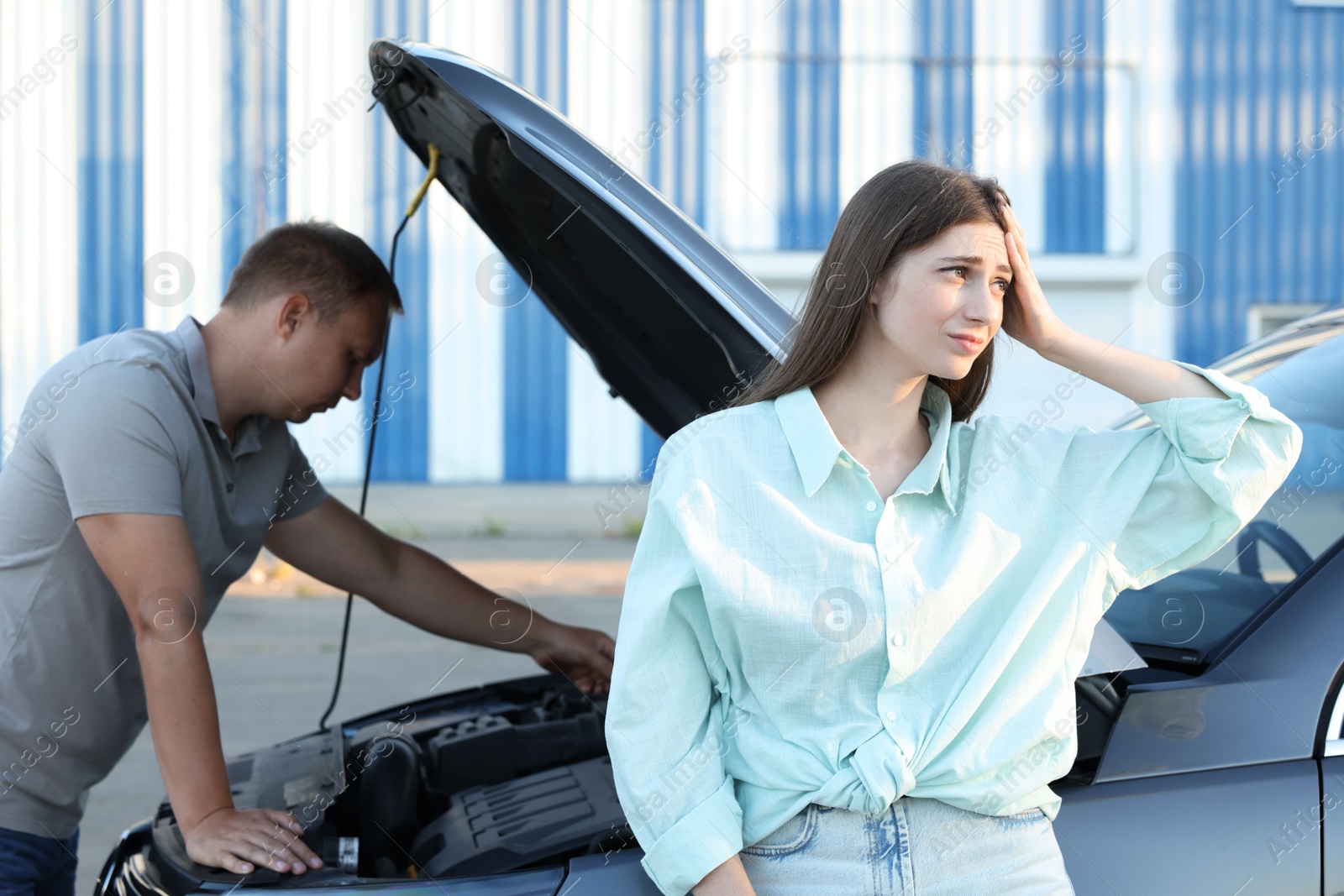 Photo of Man and woman near broken car outdoors