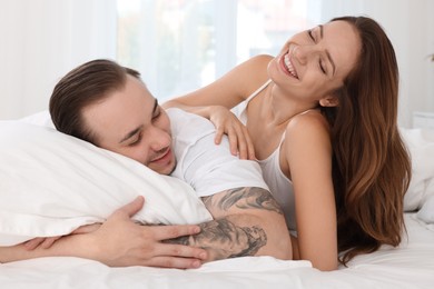 Happy couple spending time together on bed at home