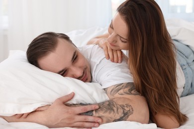 Photo of Cute couple spending time together on bed at home