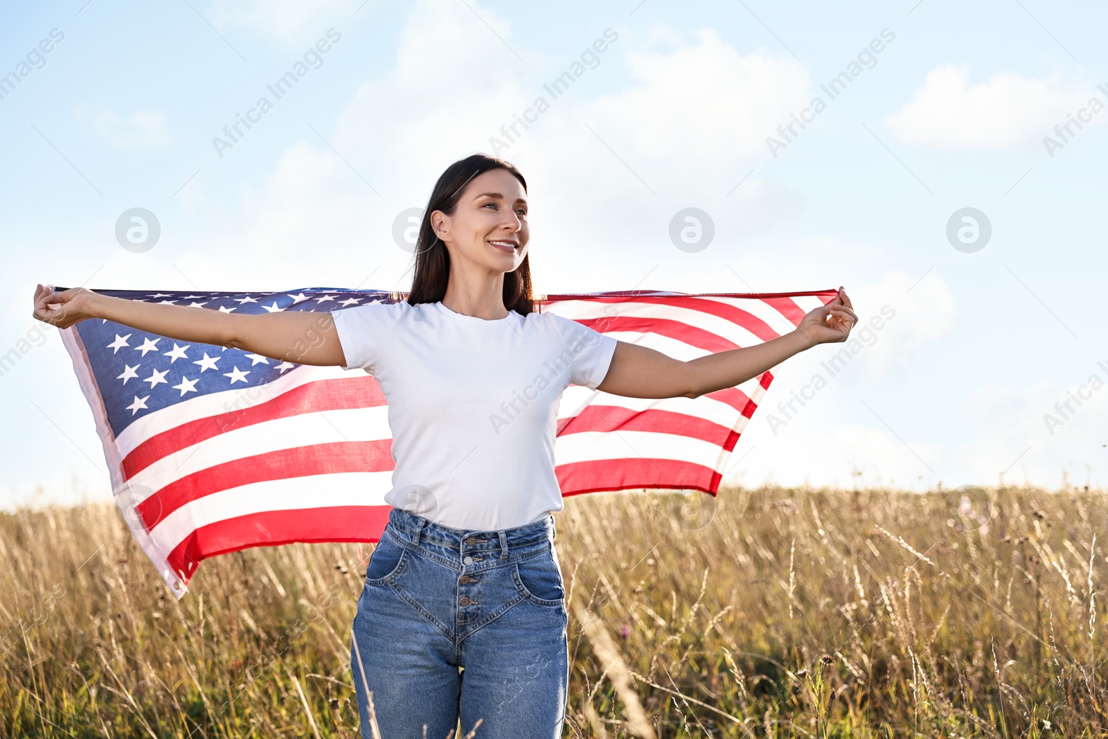 Photo of Happy woman with flag of USA outdoors