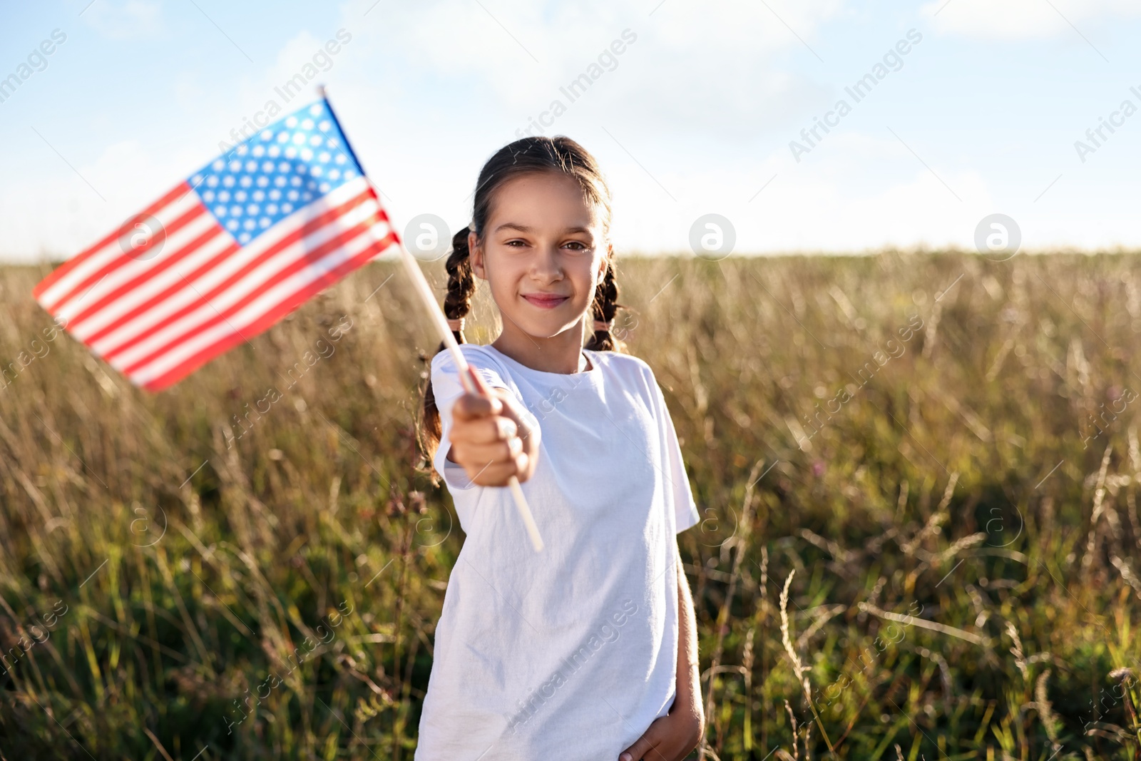 Photo of Little girl with flag of USA outdoors