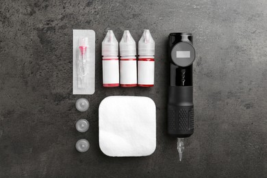 Permanent makeup equipment kit on grey table, flat lay