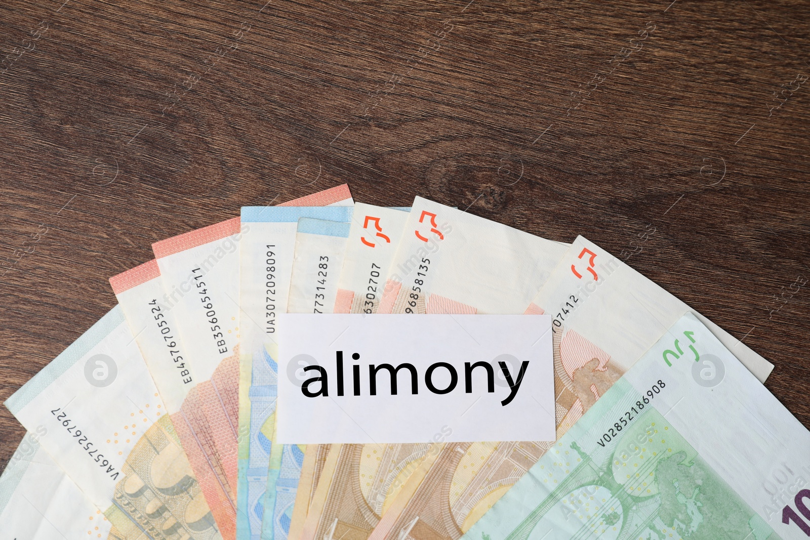 Photo of Alimony. Blank card and euro banknotes on wooden table, top view