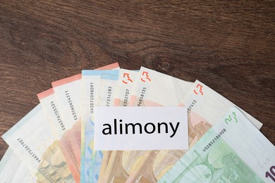 Alimony. Blank card and euro banknotes on wooden table, top view