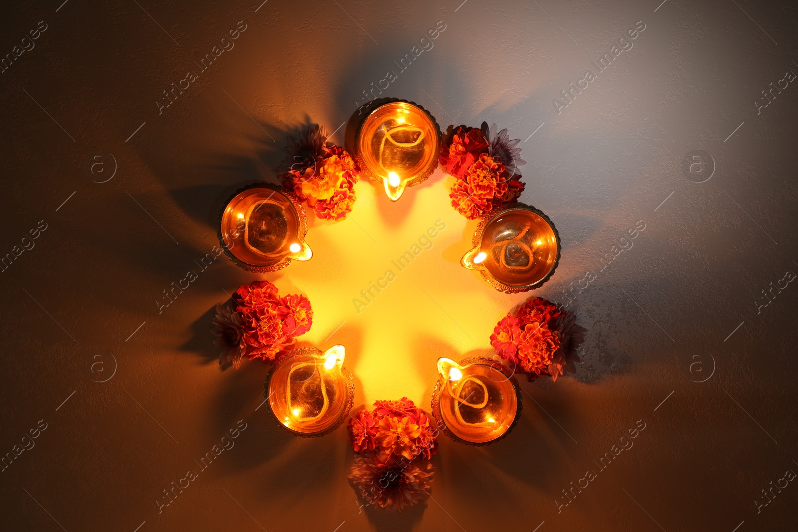 Photo of Diwali celebration. Diya lamps and beautiful flowers on dark textured surface, flat lay. Space for text