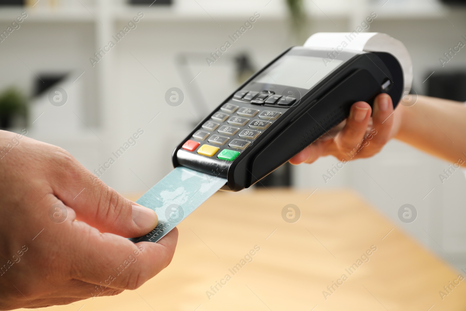 Photo of Customer making payment by putting credit card into POS machine indoors, closeup