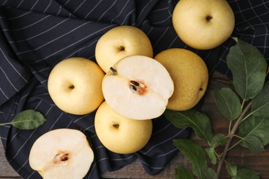 Photo of Delicious fresh apple pears and green leaves on wooden table, top view