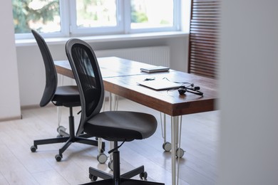 Photo of Black chairs, laptop and desk in office