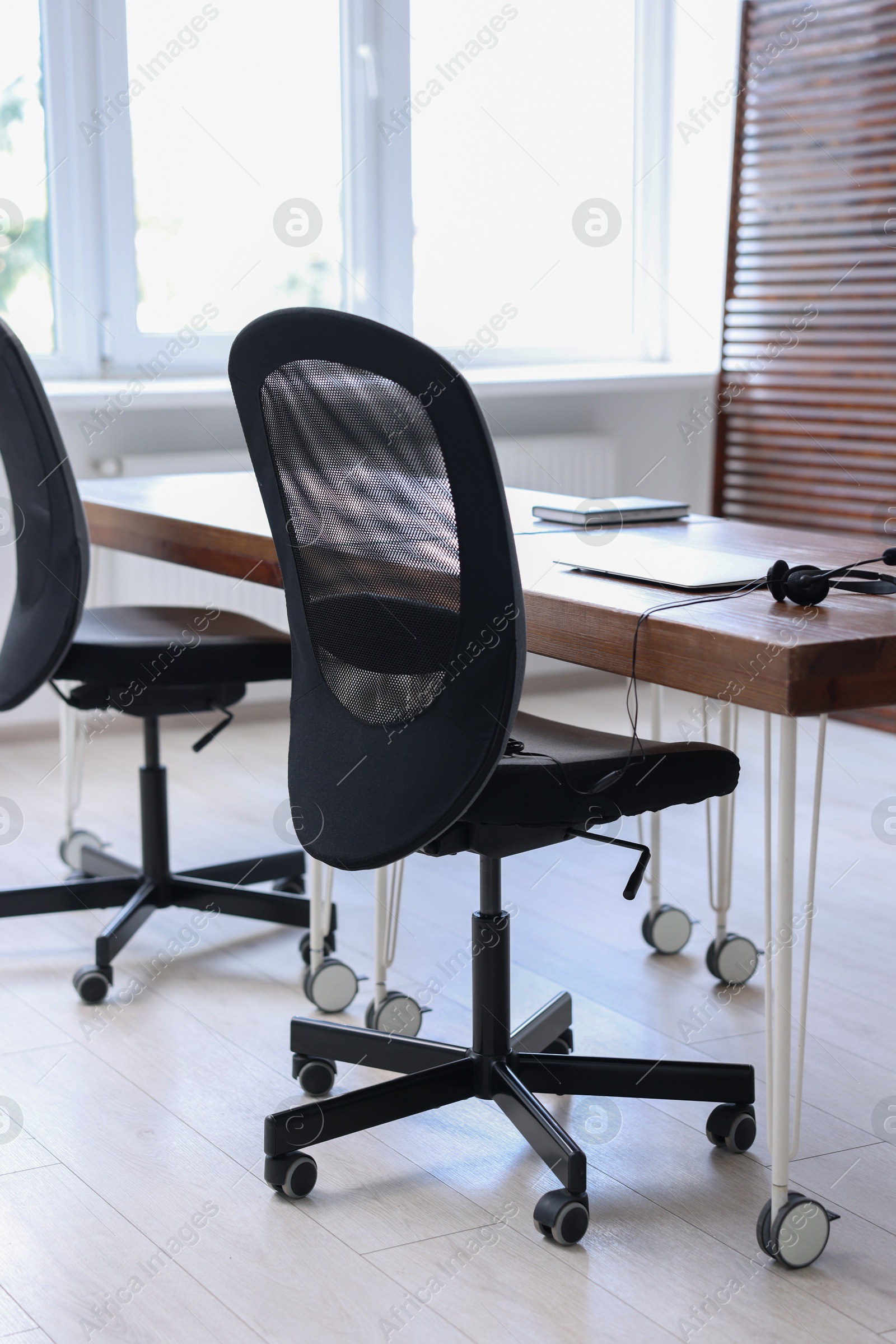 Photo of Black chairs, laptop and desk in office