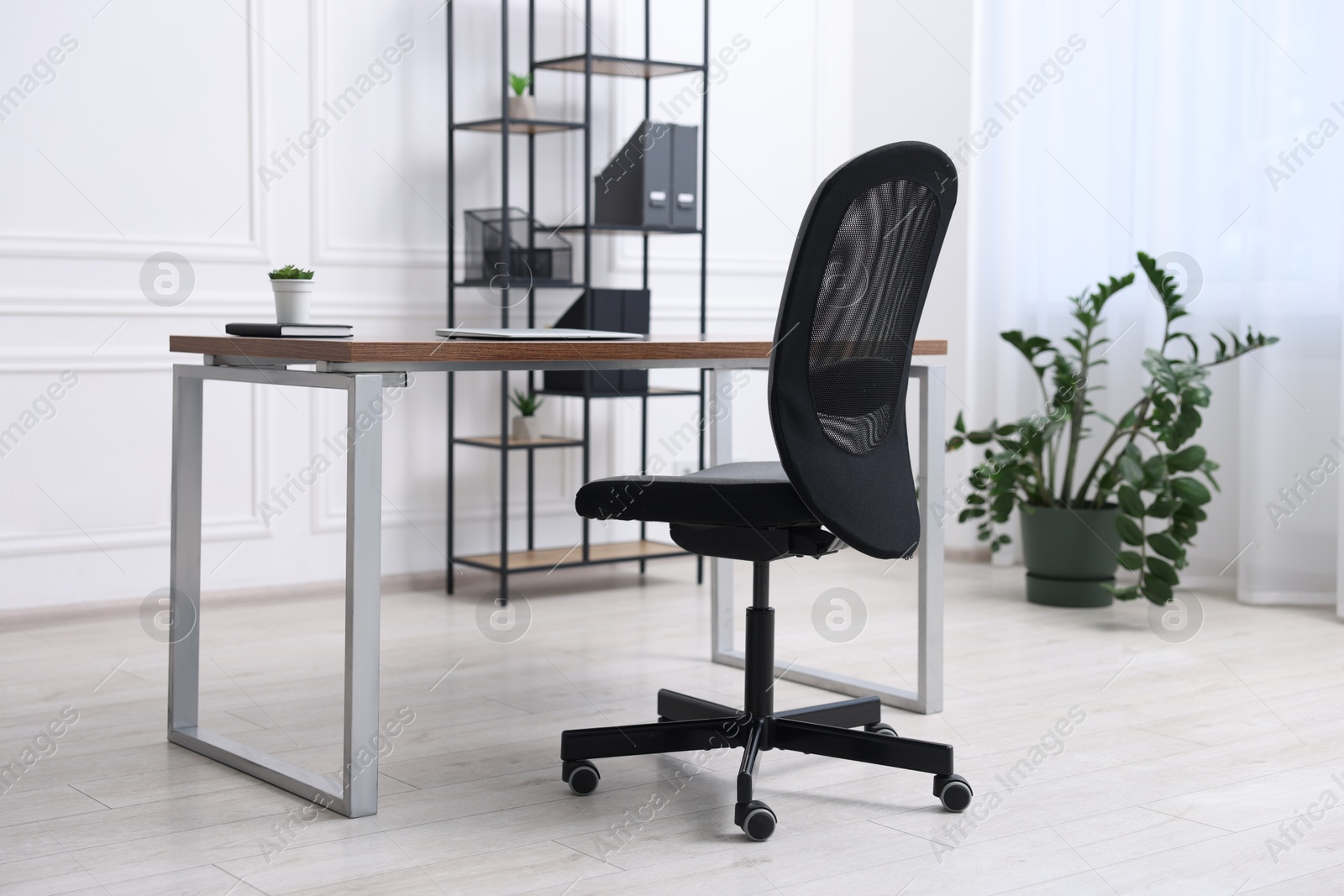 Photo of Black chair, laptop and desk in office