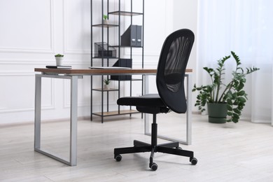 Photo of Black chair, laptop and desk in office