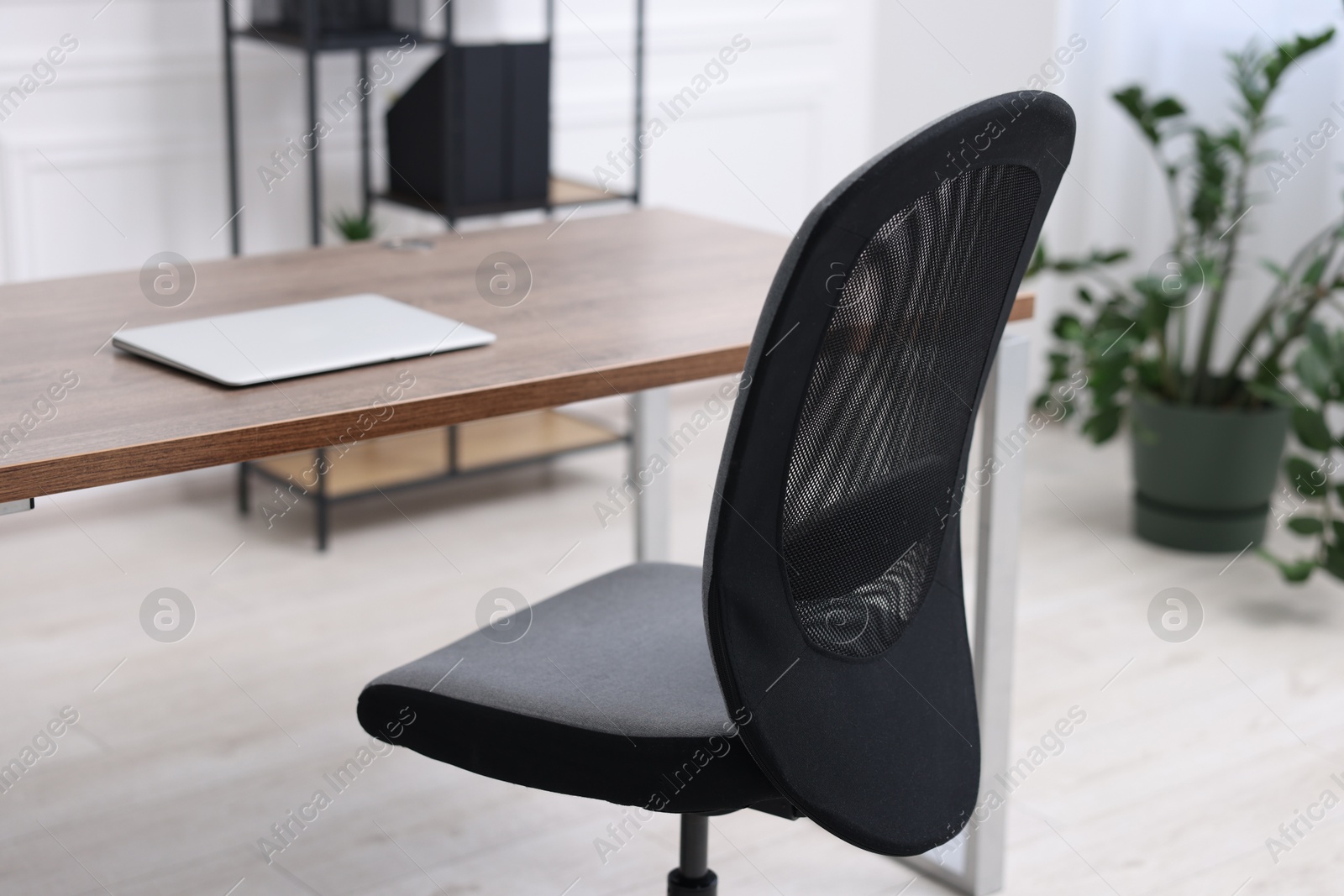 Photo of Black chair, laptop and desk in office