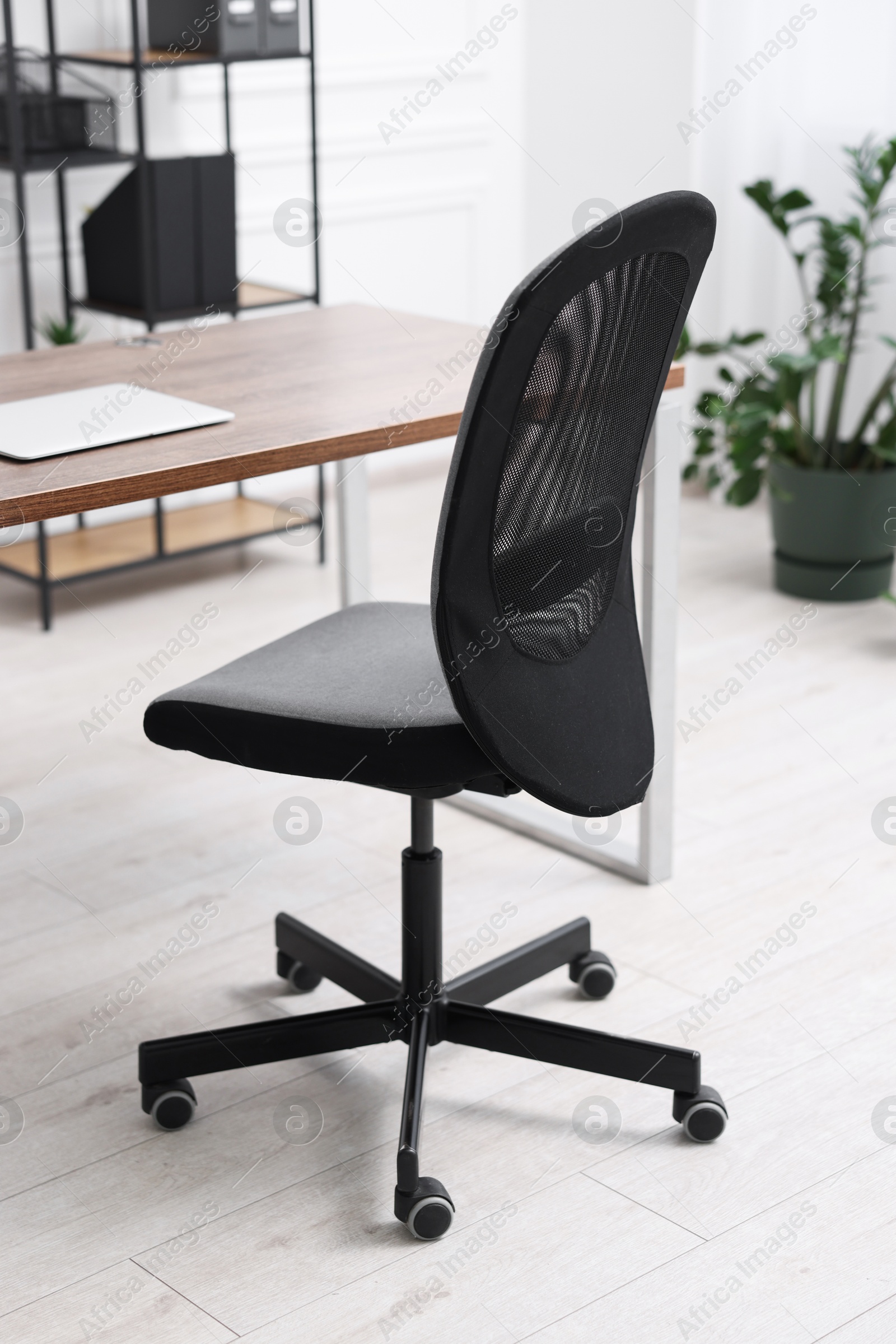 Photo of Black chair, laptop and desk in office