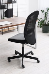 Photo of Black chair, laptop and desk in office