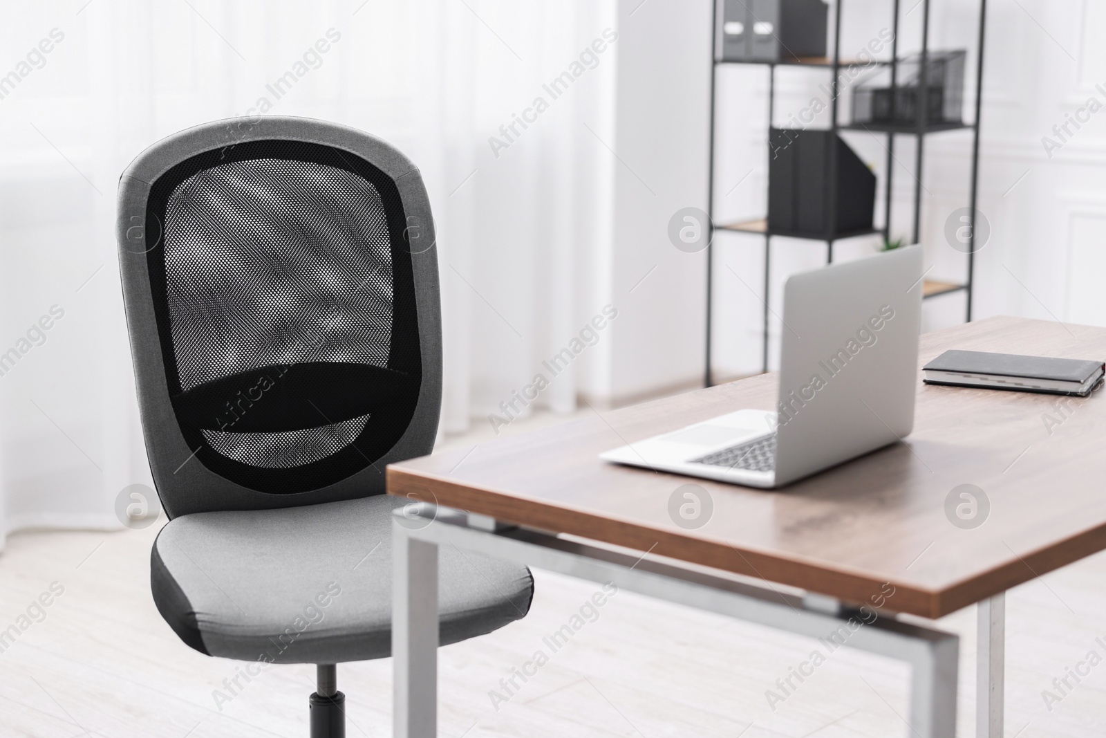 Photo of Black chair, laptop and desk in office