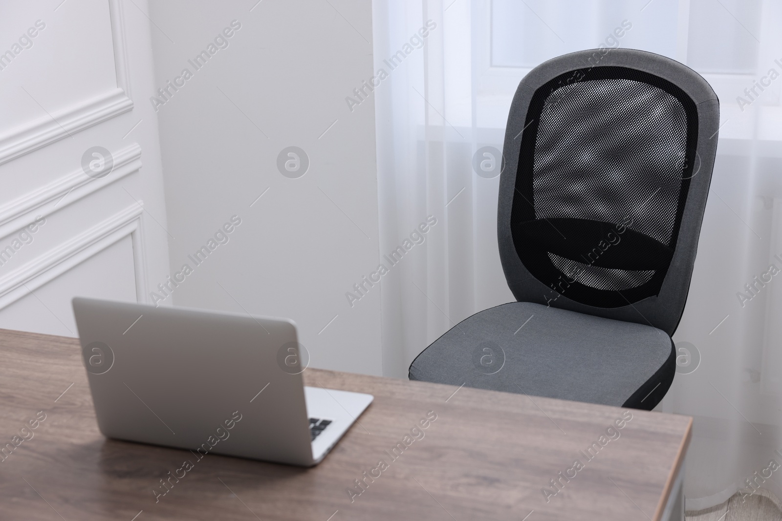 Photo of Black chair, laptop and desk in office