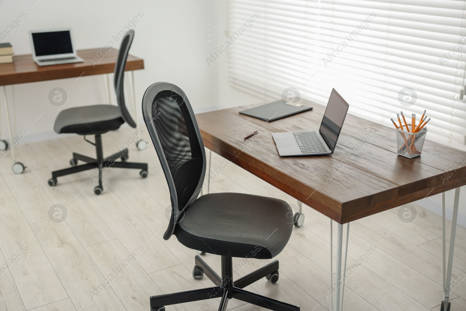 Photo of Black chair, laptop and desk in office