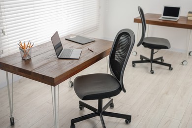 Black chair, laptop and desk in office