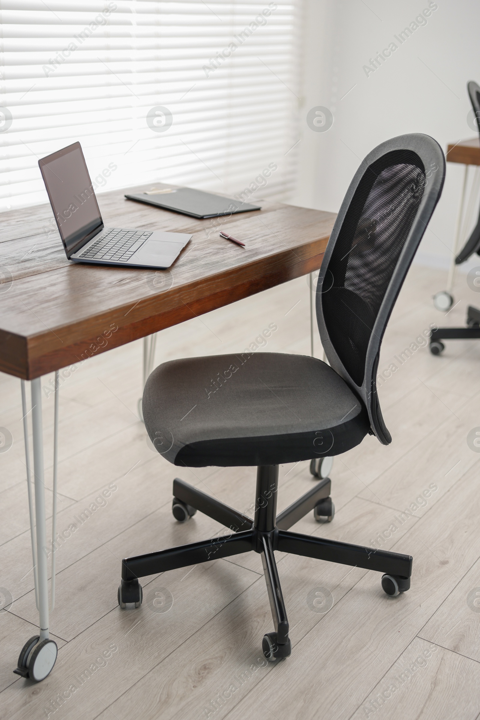 Photo of Black chair, laptop and desk in office