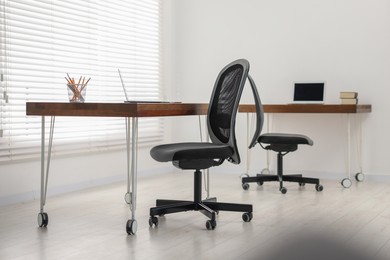 Black chair, laptop and desk in office