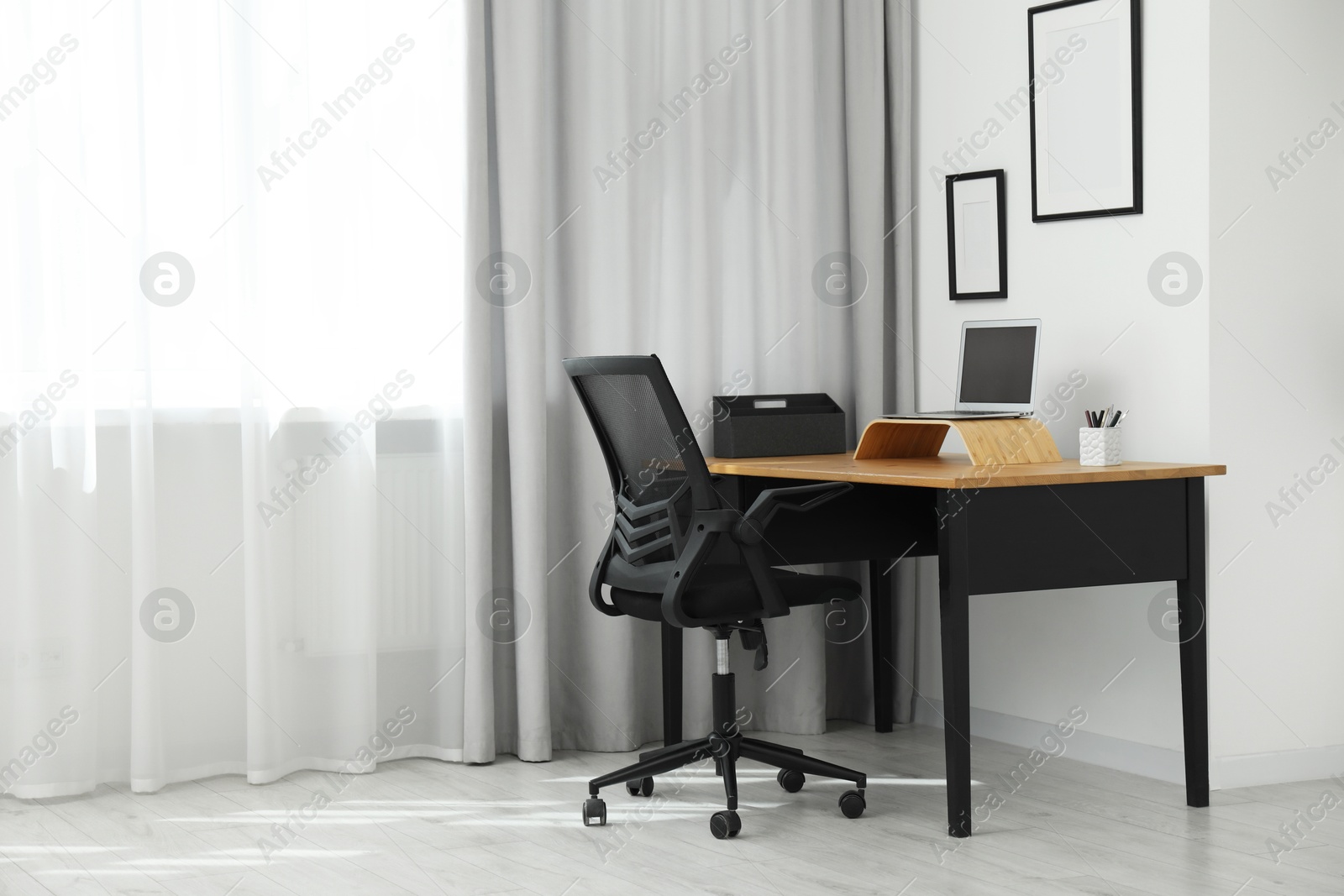 Photo of Black chair, laptop and desk in office