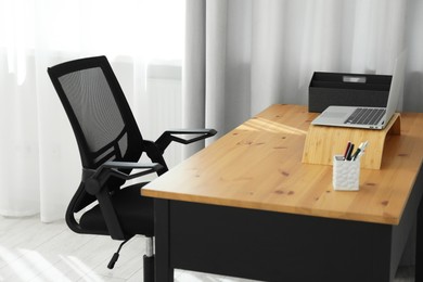 Photo of Black chair, laptop and desk in office