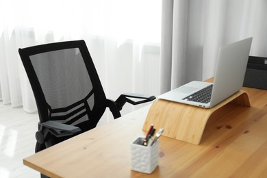 Black chair, laptop and desk in office