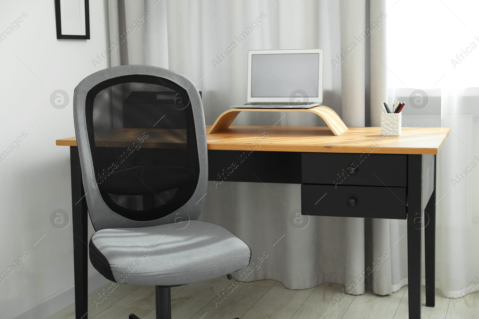 Photo of Grey chair, laptop and desk in office