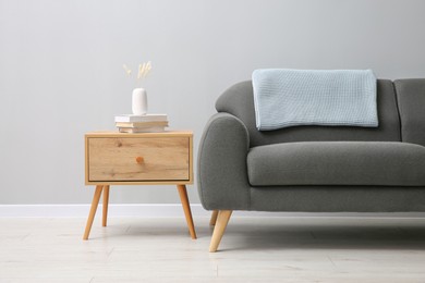 Photo of Comfortable sofa and table near grey wall in room