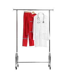 Photo of Paramedic uniform and doctor's coat with stethoscope on clothing rack against white background