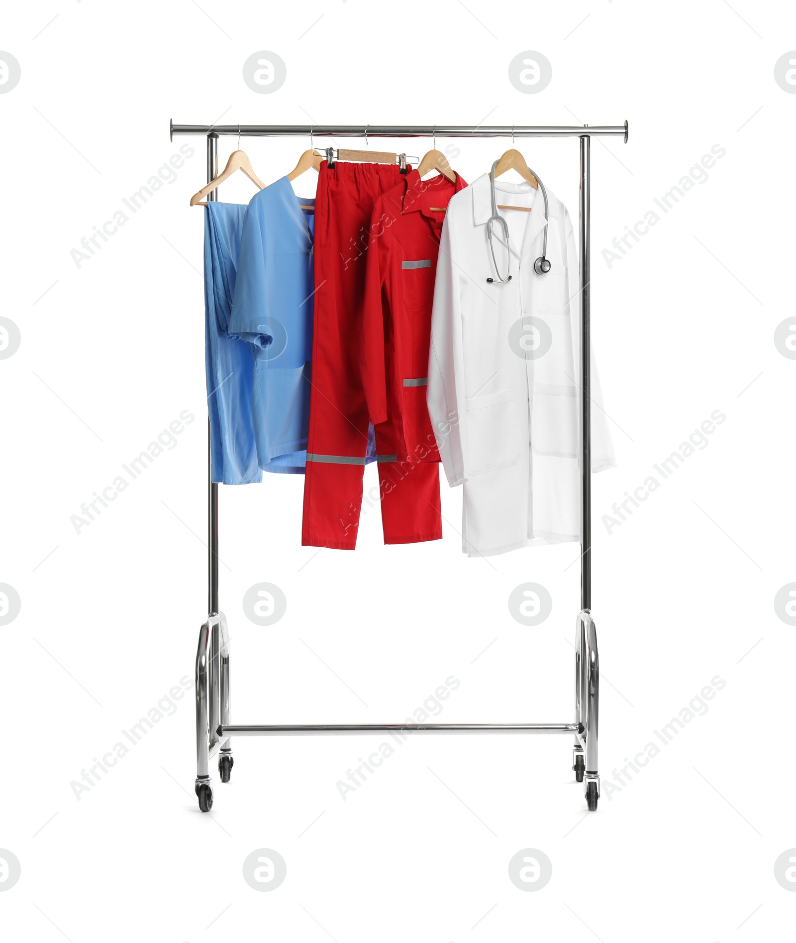 Photo of Different medical workers' uniforms and stethoscope on clothing rack against white background