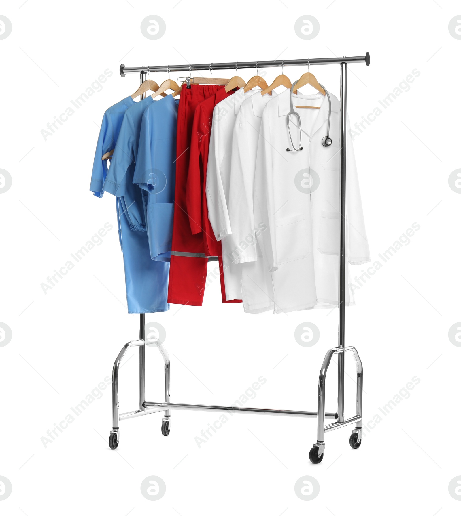 Photo of Different medical workers' uniforms and stethoscope on clothing rack against white background