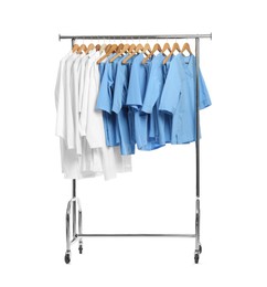 Photo of Different medical workers' uniforms on clothing rack against white background