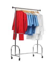 Different medical workers' uniforms on clothing rack against white background