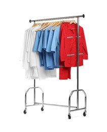 Photo of Different medical workers' uniforms on clothing rack against white background