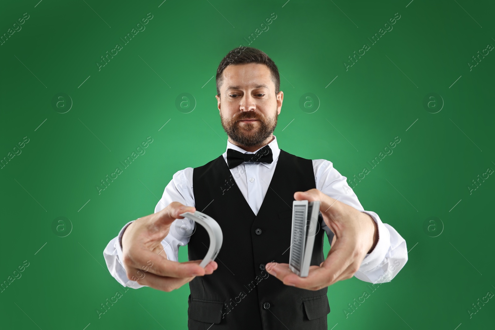 Photo of Professional croupier shuffling cards on green background