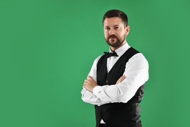 Portrait of professional croupier on green background, space for text