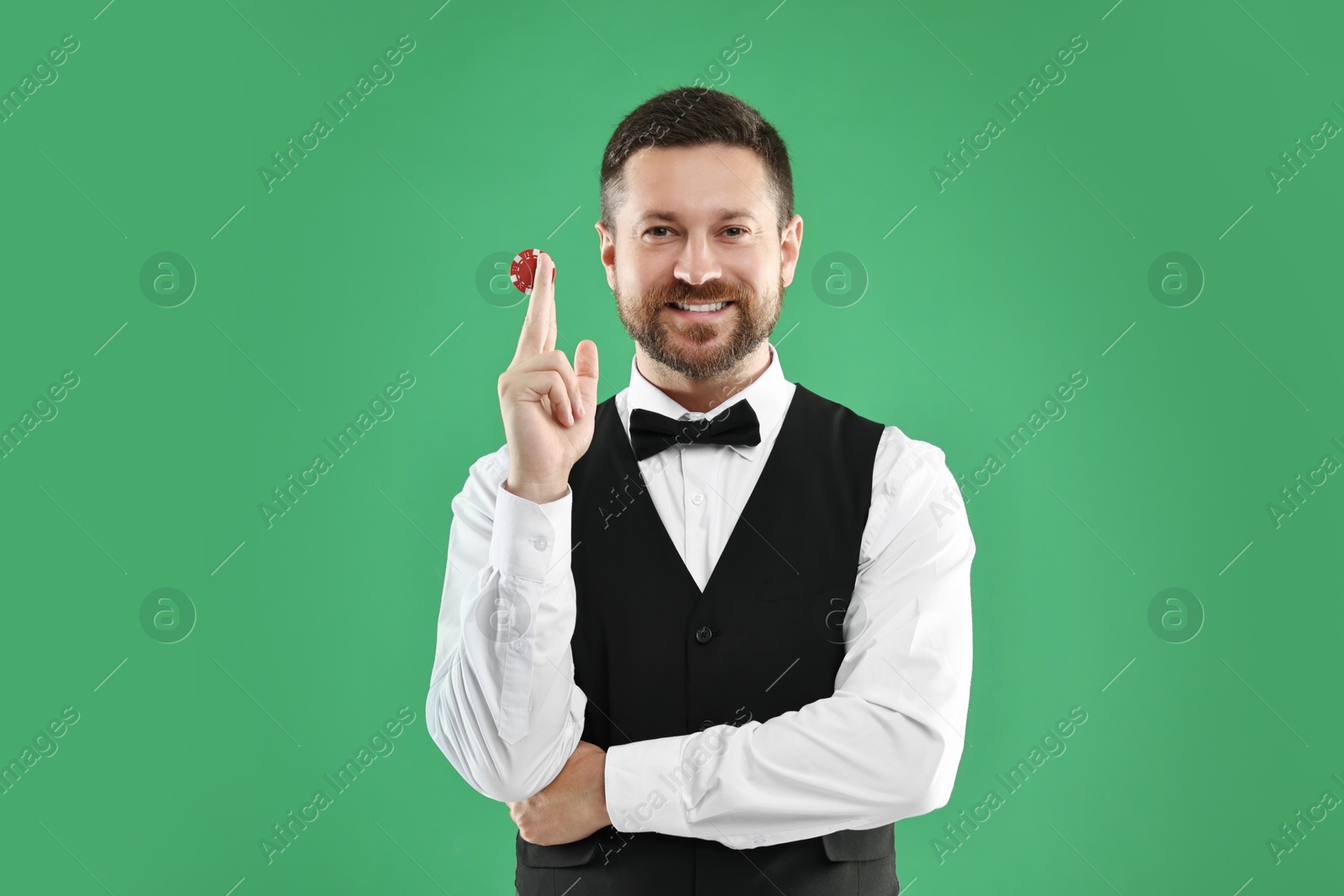 Photo of Croupier with casino chip on green background